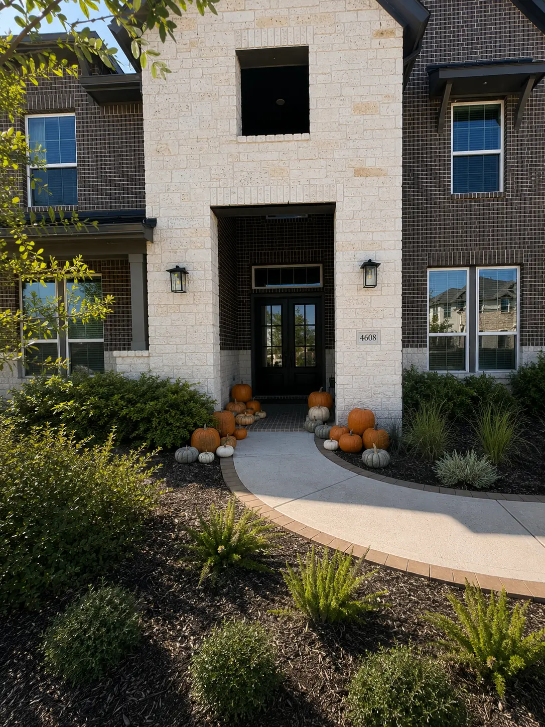 The Porch Edit fall pumpkin porch installation with orange, white and heirloom pumpkins styled on a home in the north Houston area