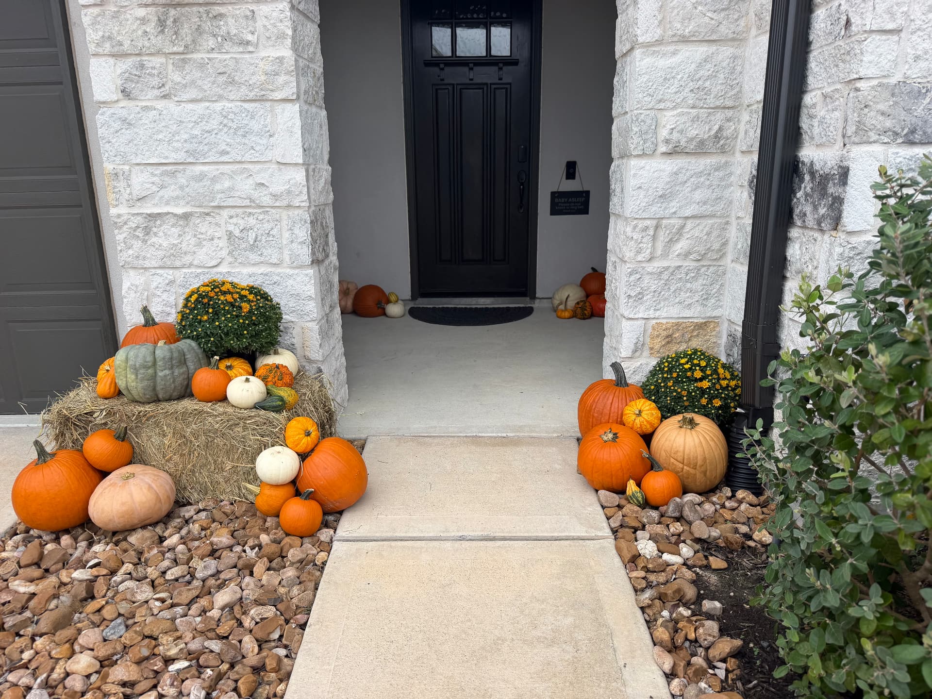 The Porch Edit fall pumpkin porch installation with orange, white and heirloom pumpkins styled on a home in the north Houston area