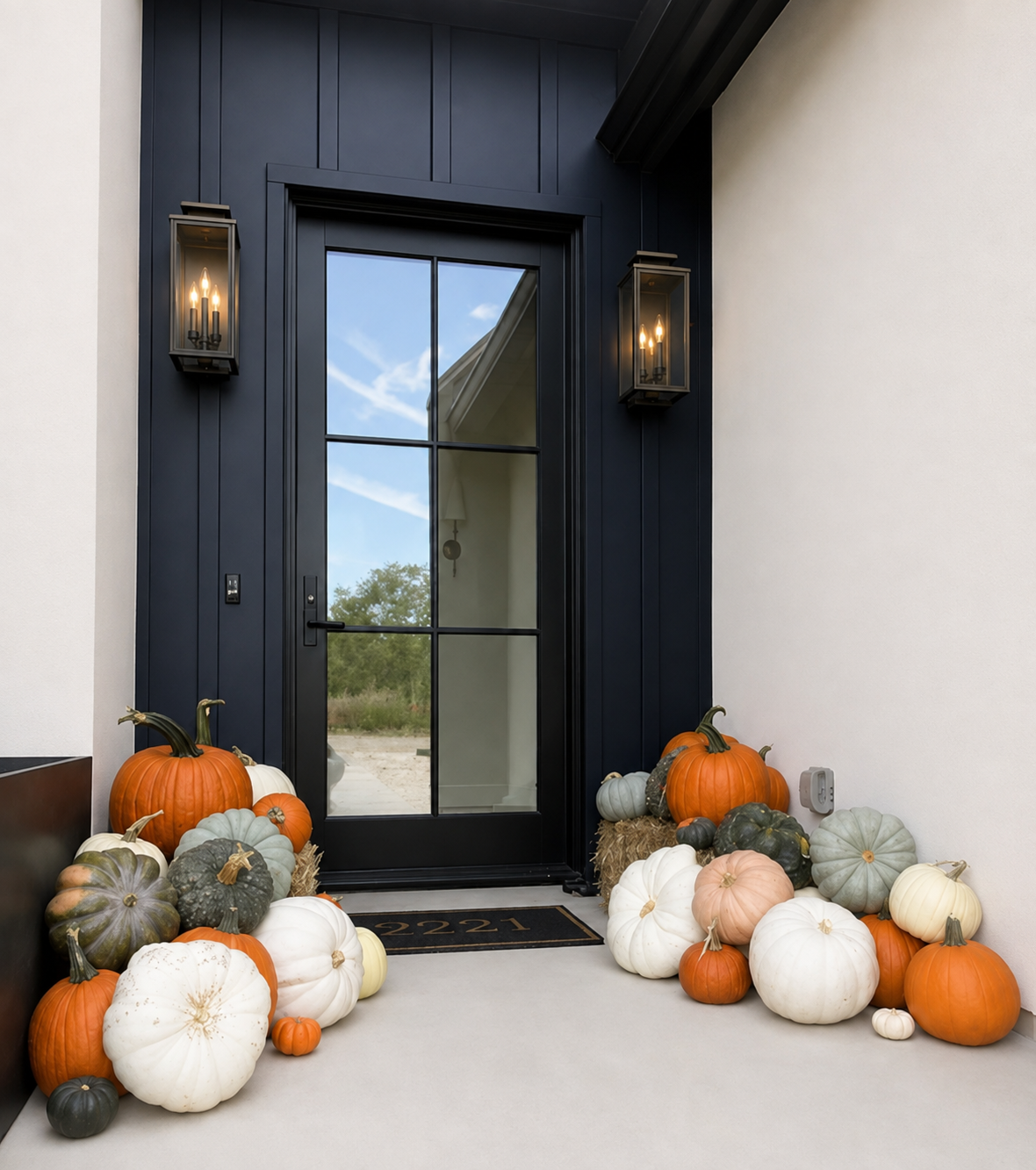 Navy front door entry styled with white, orange and heirloom pumpkins and hay bales